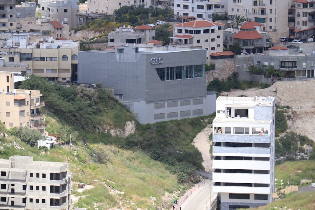 נדלן בשכונת אגמים — נוף אורבני של שכונת אגמים נתניה עם בנייני מגורים מודרניים ואגם, המייצג את פוטנציאל הנדלן בשכונה.
